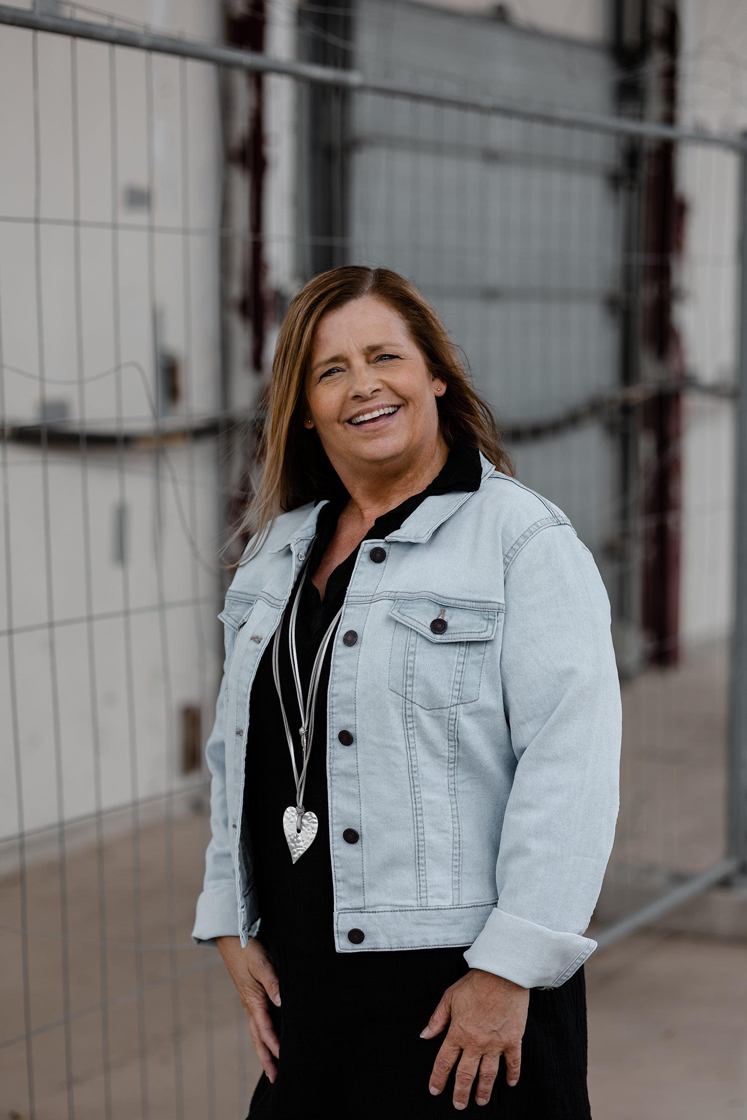 Profielfoto van Dianne Schottert, eigenaresse van een creatieve webshop in gepersonaliseerde cadeaus – lachend en gekleed in spijkerjasje met hartketting.