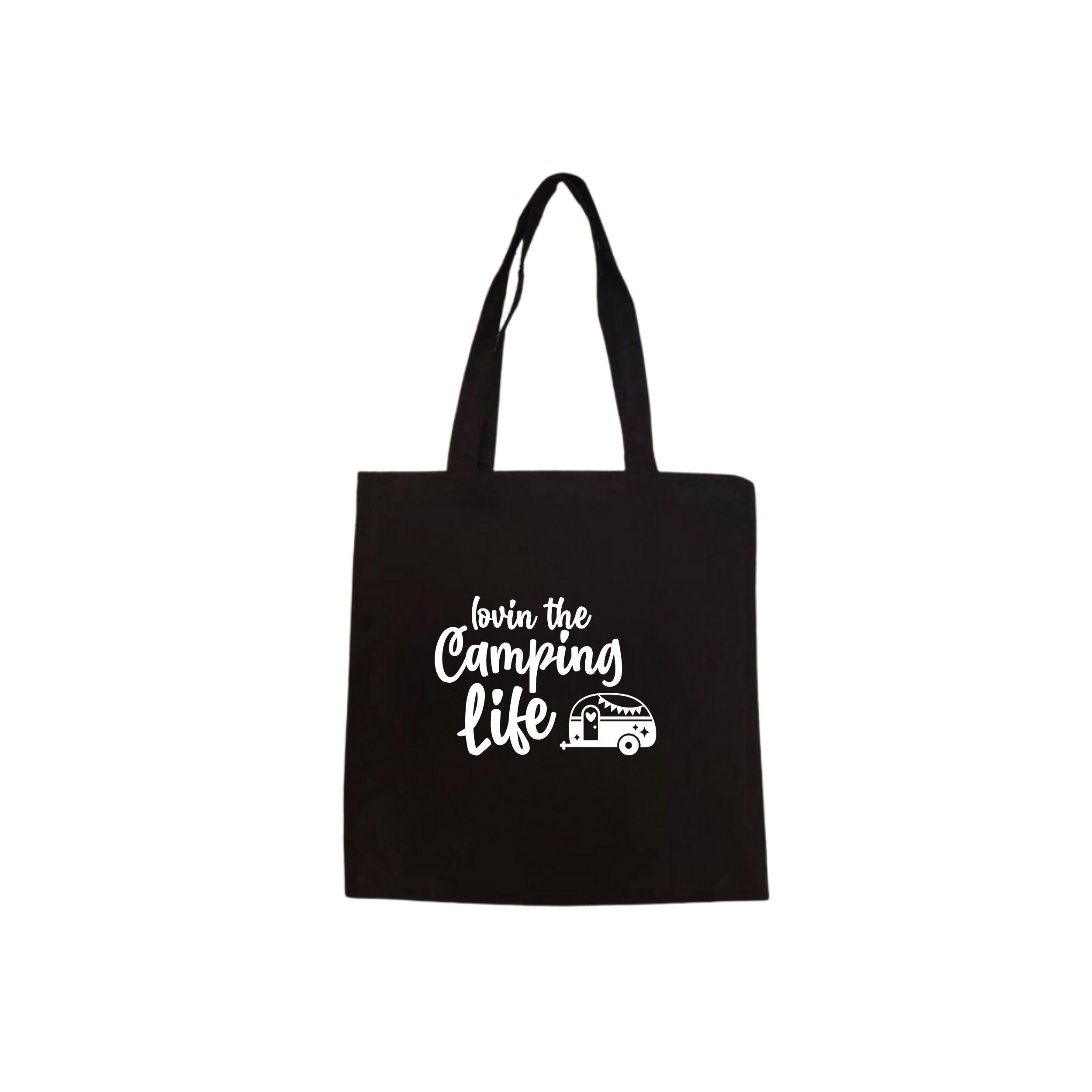 Zwarte canvas tote bag met caravan illustratie en de tekst ‘Lovin the Camping Life’.
