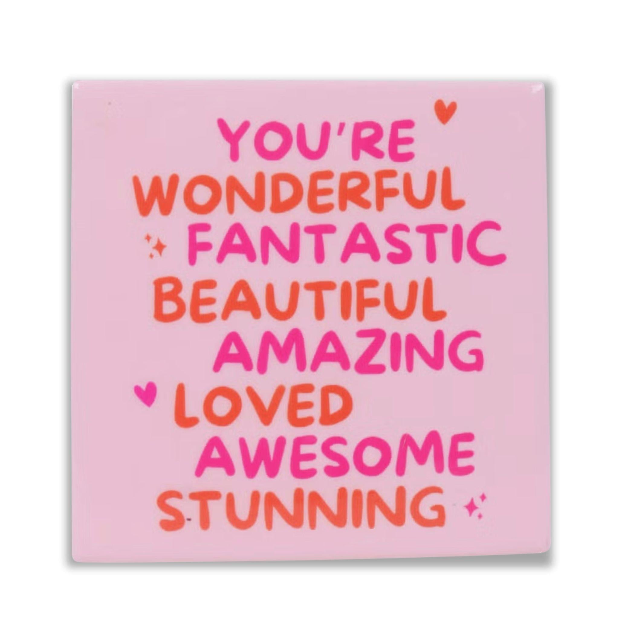 Keramisch tegeltje met kleurrijke tekst you are wonderful fantastic beautiful amazing loved awesome stunning op een roze achtergrond Studio DSigns